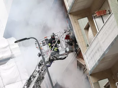 Firefighters spray water at a house on fire following an explosion in the centre of Milan, Italy, May 11, 2023. REUTERS/Claudia Greco