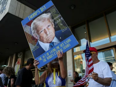 A person holds a placard with an image of U.S. President Donald Trump in "Hostages square", after a ceasefire between Israel and Hamas in Gaza went into effect, in Tel Aviv, Israel, October 11, 2025. REUTERS/Ronen Zvulun