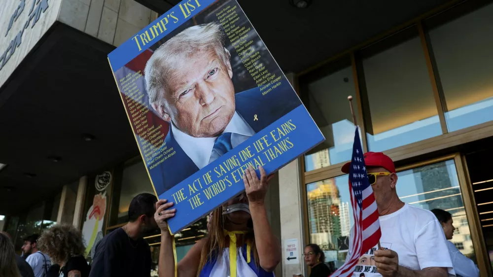 A person holds a placard with an image of U.S. President Donald Trump in "Hostages square", after a ceasefire between Israel and Hamas in Gaza went into effect, in Tel Aviv, Israel, October 11, 2025. REUTERS/Ronen Zvulun