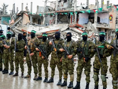 FILE PHOTO: Palestinian Hamas militants stand guard on the day of the handover of hostages held in Gaza since the deadly October 7 2023 attack, as part of a ceasefire and a hostages-prisoners swap deal between Hamas and Israel, in Rafah in the southern Gaza Strip, February 22, 2025. REUTERS/Hatem Khaled/File Photo