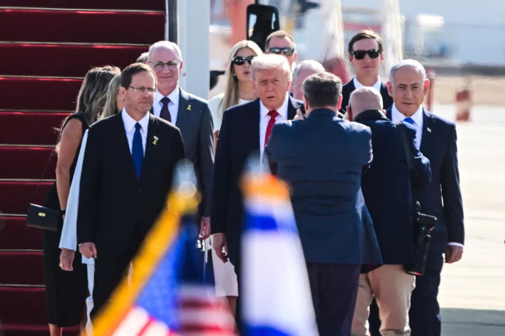 U.S. President Donald Trump walks with Israeli President Isaac Herzog, Israeli Prime Minister Benjamin Netanyahu and others at Ben Gurion International airport, on the day Israeli hostages are released by Hamas and Palestinian prisoners by Israel after a ceasefire went into effect under the first phase of a U.S.-brokered agreement, in Lod, Israel October 13, 2025. REUTERS/Yossi Zeliger  ISRAEL OUT. NO COMMERCIAL OR EDITORIAL SALES IN ISRAEL