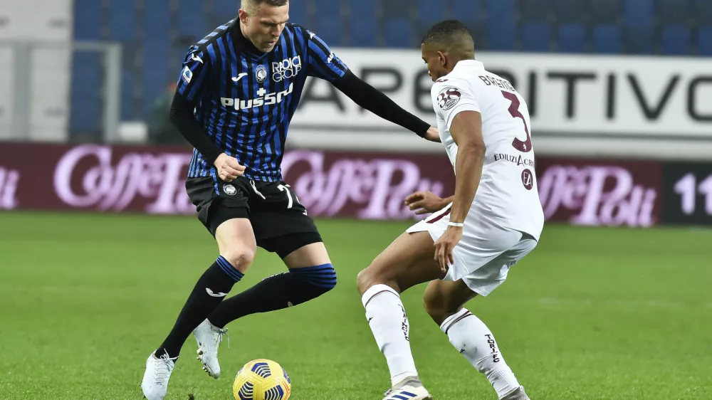 Atalanta's Josip Ilicic, left, takes on Torino's Gleison Bremer during the Serie A soccer match between Torino and Atalanta, at the Gewiss Stadium in bergamo, Italy, Saturday, Feb. 6, 2021. (Gianluigi Checchi/LaPresse via AP)