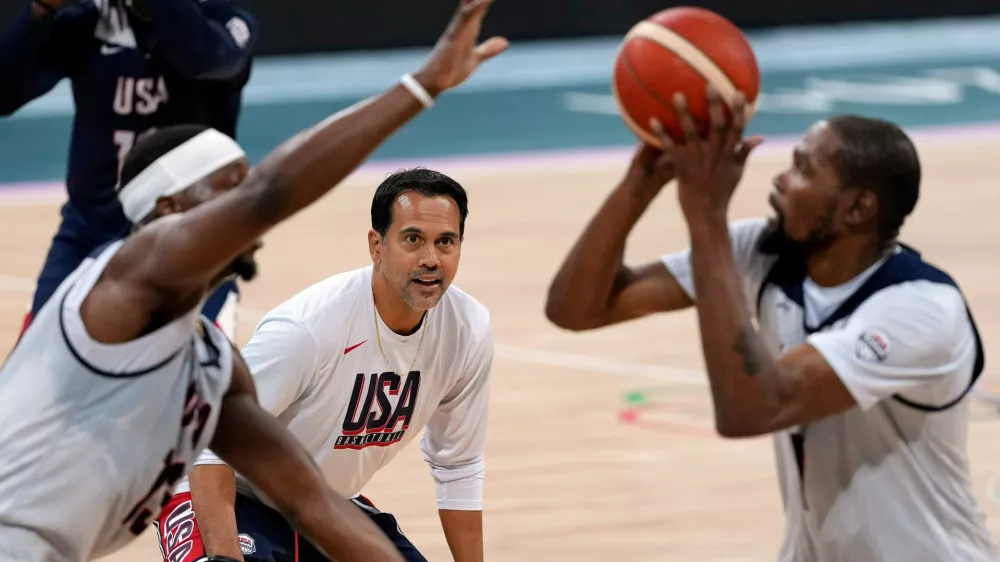 FILE - United State's Kevin Durant, right, shoots as Bam Adebayo, left, defends while assistant coach Erik Spoelstra watches during men's basketball practice at the 2024 Summer Olympics, Wednesday, July 24, 2024, in Villeneuve-d'Ascq, France. (AP Photo/Mark J. Terrill, File)
