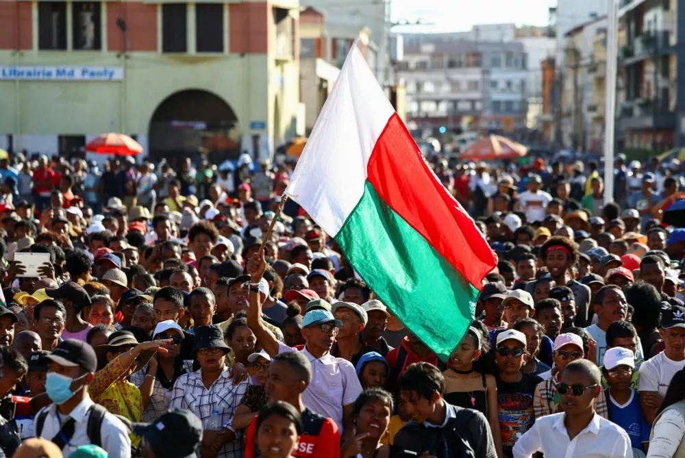 A protester waves his country's flag as demonstrators gather outside the town hall on Independence Avenue during a nationwide youth-led protest over frequent power outages and water shortages, in Antananarivo, Madagascar, October 13, 2025. REUTERS/Siphiwe Sibeko