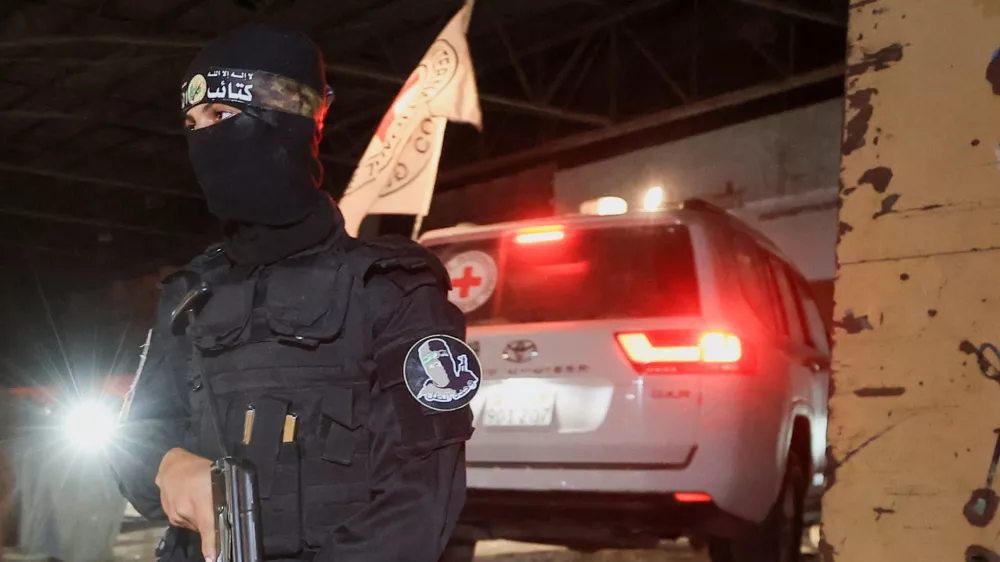 An armed Hamas militant stands guard as a Red Cross vehicle arrives to receive from Hamas militants the bodies of deceased hostages who had been held in Gaza since the deadly October 7, 2023 attack, as part of a ceasefire and a hostages-prisoners swap deal between Hamas and Israel, in Gaza City, October 14, 2025. REUTERS/Dawoud Abu Alkas