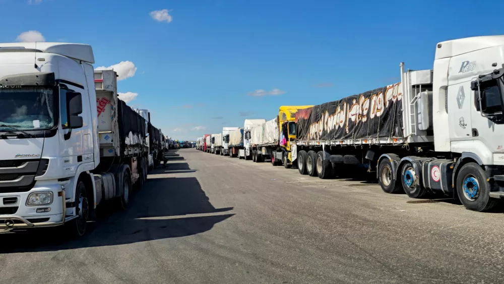 Trucks carrying humanitarian aid prepared by the Egyptian Red Crescent, which are to enter the Rafah crossing into the Gaza Strip tomorrow, line up, after a ceasefire between Israel and Hamas in Gaza went into effect, in Al-Arish, the capital of the North Sinai Governorate, Egypt, October 14, 2025. REUTERS/Stringer
