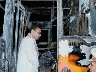 This photograph shared by Indian State Rajasthan Chief Minister's office shows Chief Minister Bhajan Lal Sharma inspecting a charred passenger bus after a suspected short circuit sparked a deadly bus fire near Jaisalmer, India, Tuesday, Oct. 14, 2025. (Rajasthan Chief Minister's office via AP)