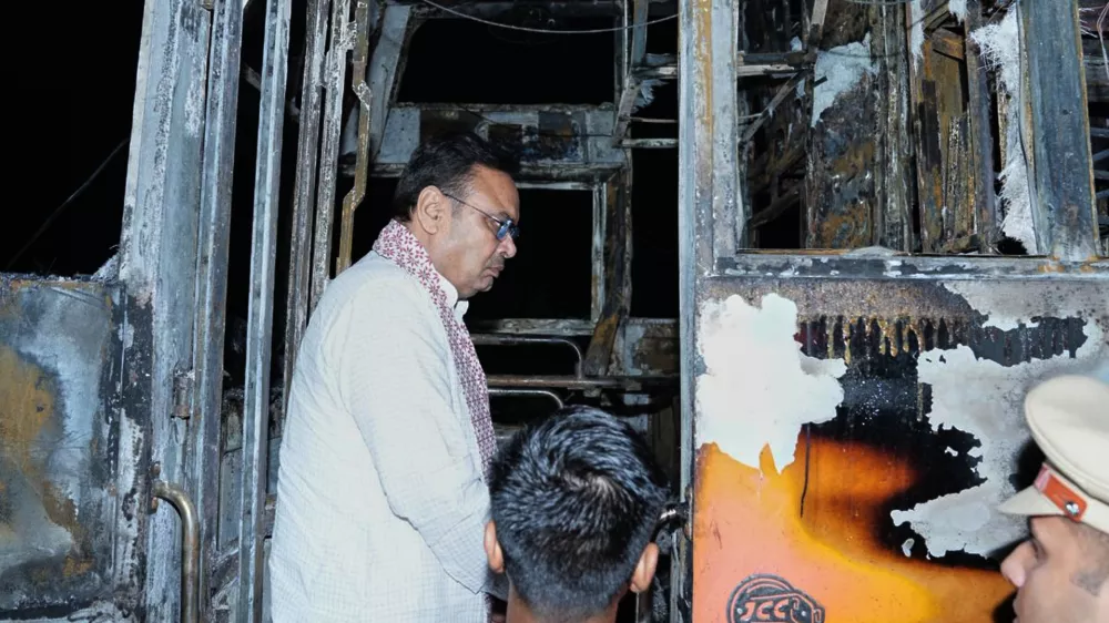 This photograph shared by Indian State Rajasthan Chief Minister's office shows Chief Minister Bhajan Lal Sharma inspecting a charred passenger bus after a suspected short circuit sparked a deadly bus fire near Jaisalmer, India, Tuesday, Oct. 14, 2025. (Rajasthan Chief Minister's office via AP)