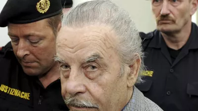 FILE - Josef Fritzl, center, is escorted to the fourth day of his trial in the provincial courthouse in St. Poelten, Austria, Thursday, March 19, 2009. An Austrian court has ruled that the man who kept his daughter captive for 24 years and raped her thousands of times, fathering seven children with her, can be moved from psychiatric detention to a regular prison. The decision follows a legal back-and-forth on Josef Fritzl's future. (AP Photo/Robert Jaeger, Pool, File)