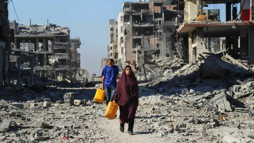 Palestinians walk past the rubble of destroyed buildings, amid a ceasefire between Israel and Hamas, in Gaza City, October 15, 2025. REUTERS/Ebrahim Hajjaj / Foto: Ebrahim Hajjaj