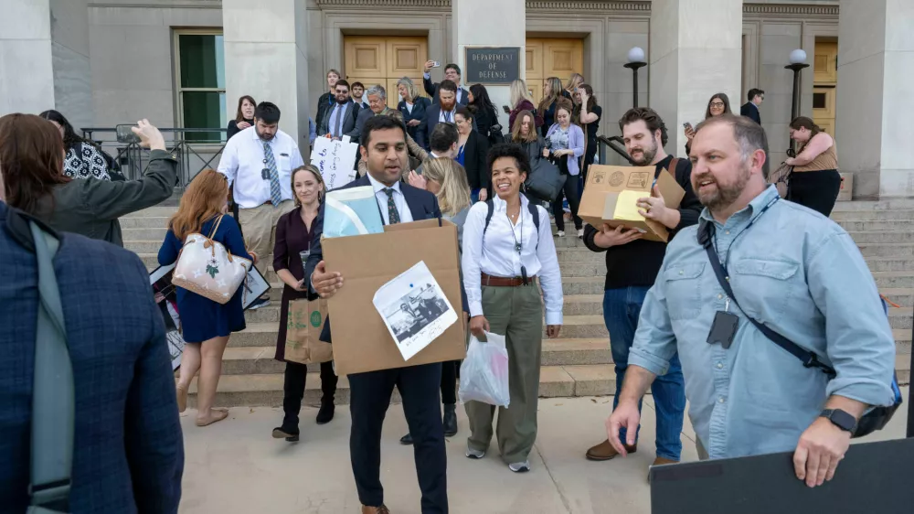 Members of the Pentagon press corp carry their belongings out of the Pentagon after turning in their press credentials, Wednesday, Oct. 15, 2025 in Washington. (AP Photo/Kevin Wolf)