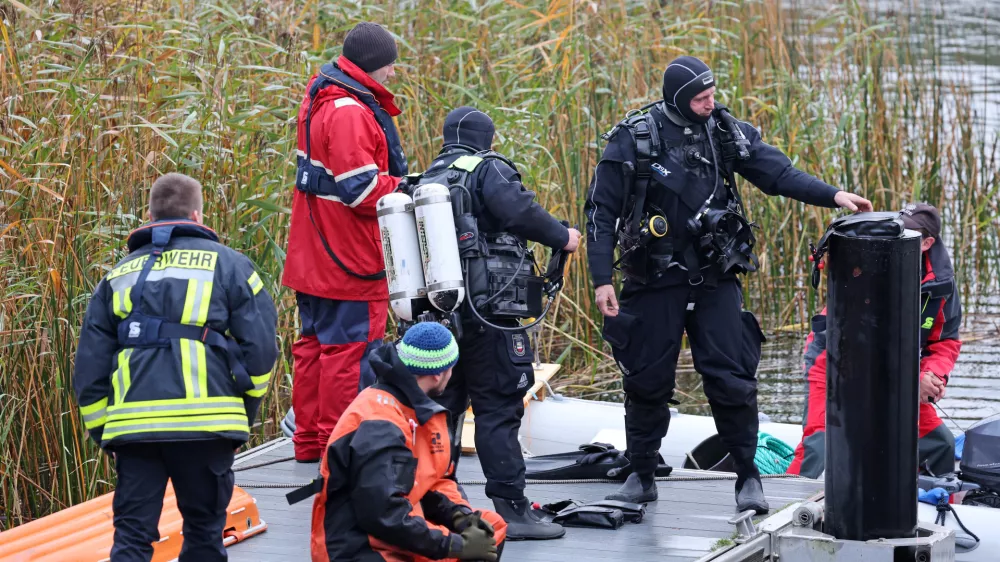 14 October 2025, Mecklenburg-Western Pomerania, Guestrow: Divers are preparing to search for missing eight-year-old Fabian at the Inselsee lake. A child's body has been found after a four-day search for a missing 8-year-old in northern Germany, with police suspecting a criminal offence in the case. Photo: Bernd Wüstneck/dpa