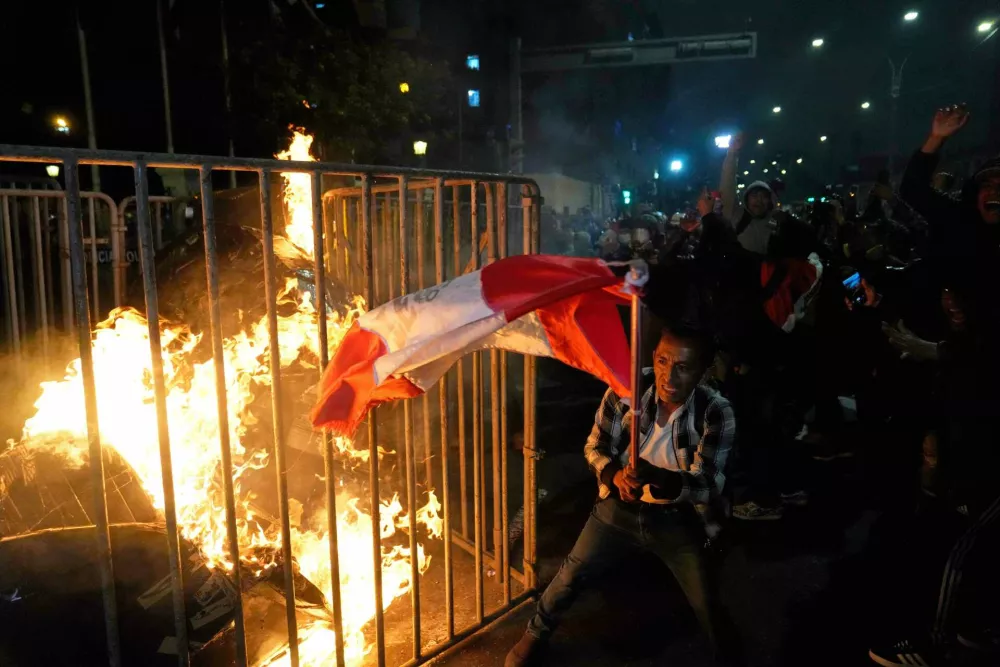 Demonstrators burn a cardboard doll in front of Congress during a protest against new President Jose Jeri in Lima, Peru, Wednesday, Oct. 15, 2025. (AP Photo/Martin Mejia)