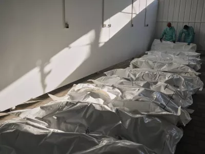 The bodies of deceased Palestinians, held by Israel during the war, lie in plastic bags on the floor of Nasser Hospital in Khan Younis, Gaza, following their release, Wednesday, Oct. 15, 2025. (AP Photo/Jehad Alshrafi)