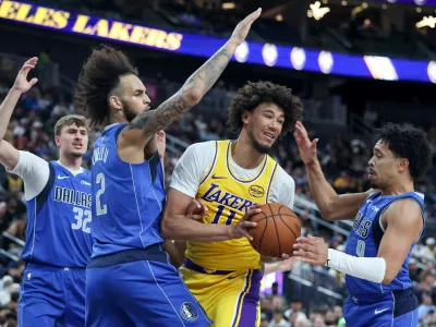 Los Angeles Lakers center Jaxson Hayes (11) secures a rebound against Dallas Mavericks center Dereck Lively II (2) and guard Ryan Nembhard (9) during the first half of a preseason NBA basketball game Wednesday, Oct. 15, 2025, in Las Vegas. (AP Photo/Ian Maule)