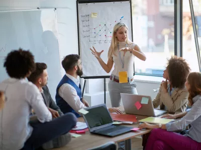 Business woman present her idea to working team.Business colleagues talking about plan or new project. / Foto: Luckybusiness