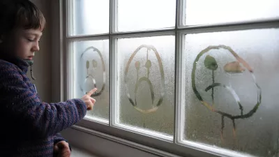 D1YK37 8 year old drawing a sad face in the condensation on a window.