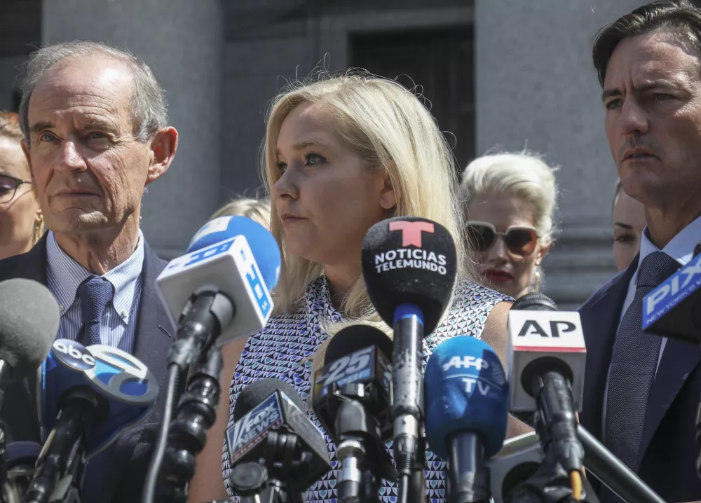 ﻿FILE - In this Aug. 27, 2019 file photo, Virginia Giuffre, center, who says she was trafficked by sex offender Jeffrey Epstein, holds a news conference outside a Manhattan court in New York. On Monday, Aug. 9, 2021, Giuffre sued Prince Andrew saying he sexually assaulted her when she was 17. Lawyers for Giuffre filed the lawsuit in Manhattan federal court. (AP Photo/Bebeto Matthews, File)