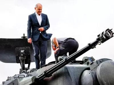 FILE PHOTO: German Chancellor Olaf Scholz climbs on a German self-propelled anti-aircraft gun Flakpanzer Gepard with head of training at arms manufacturer Krauss-Maffei Juergen Schoch, during a visit of the training program for Ukrainian soldiers on the Gepard anti-aircraft tank in Putlos near Oldenburg, Germany August 25, 2022. Axel Heimken/Pool via REUTERS/File Photo