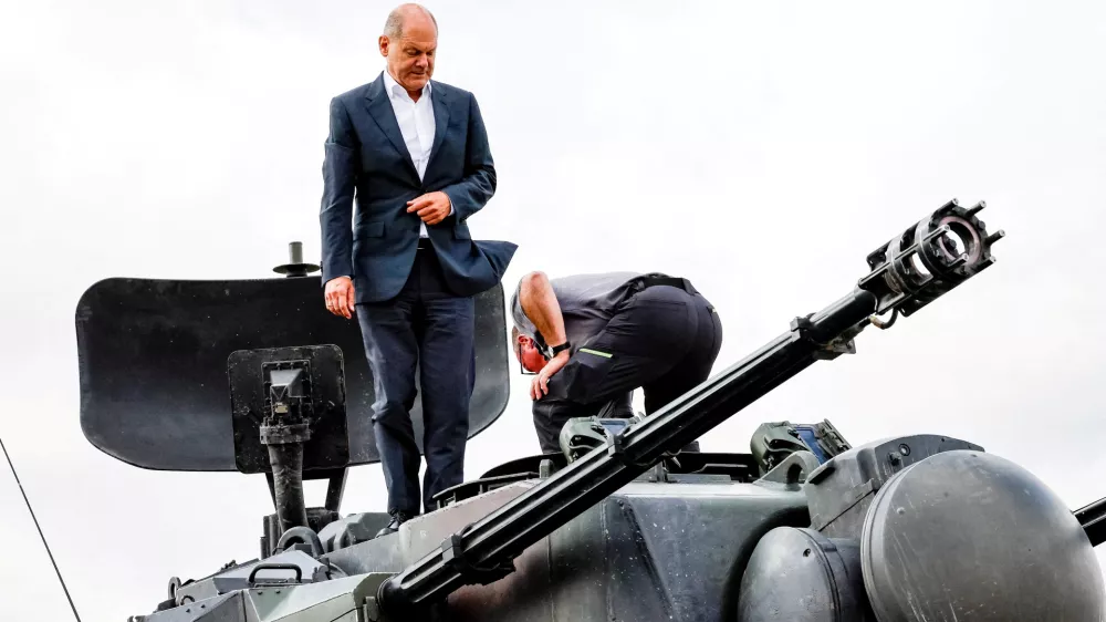 FILE PHOTO: German Chancellor Olaf Scholz climbs on a German self-propelled anti-aircraft gun Flakpanzer Gepard with head of training at arms manufacturer Krauss-Maffei Juergen Schoch, during a visit of the training program for Ukrainian soldiers on the Gepard anti-aircraft tank in Putlos near Oldenburg, Germany August 25, 2022. Axel Heimken/Pool via REUTERS/File Photo