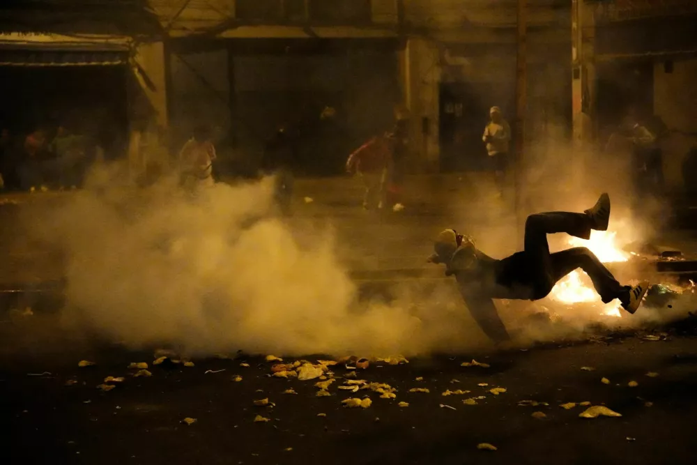 A demonstrator falls to the ground amidst the smoke during a protest against rising crime, economic insecurity, and corruption, a day after President Jose Jeri presented his cabinet, in Lima, Peru, October 15, 2025. REUTERS/Angela Ponce
