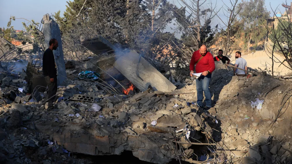 People look at the site of an Israeli airstrike on a cement plant in the southern Lebanese village of Ansar, Lebanon, Friday, Oct. 17, 2025. (AP Photo/Mohammad Zaatari)