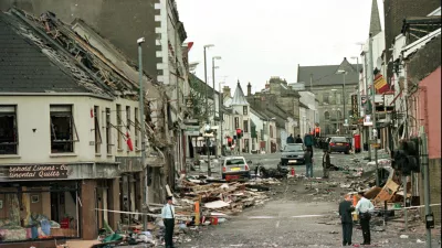 FILE - Royal Ulster Constabulary Police officers stand on Market Street, the scene of a car bombing in the centre of Omagh, Co Tyrone, 72 miles west of Belfast, Northern Ireland, on Aug. 15, 1998. (AP Photo/Paul McErlane, File)