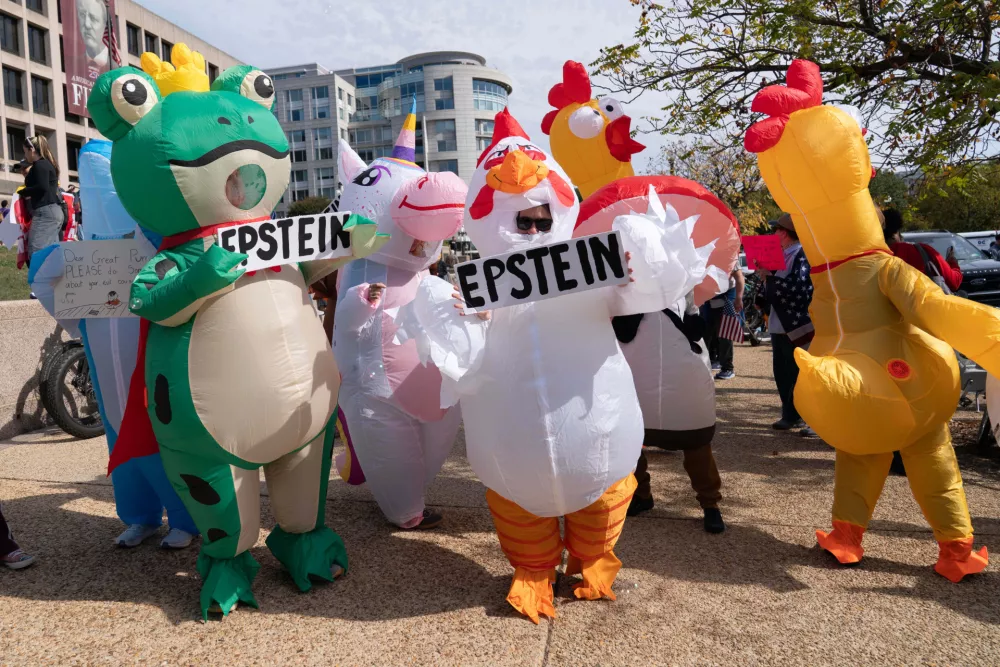 Demonstrators in inflatable costumes rally on Pennsylvania Avenue during a No Kings protest in Washington, Saturday, Oct. 18, 2025. (AP Photo/Jose Luis Magana)