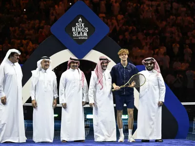 Tennis - Six Kings Slam - ANB Arena, Riyadh, Saudi Arabia - October 18, 2025 Italy's Jannik Sinner poses with a racket, Yasir Al-Rumayyan and the Chairman of Saudi Arabia's General Entertainment Authority, Turki Al-Sheikh after winning the final against Spain's Carlos Alcaraz REUTERS/Stringer
