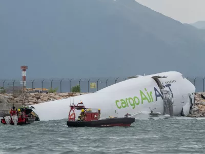 Responders on boats float around the cargo aircraft that skidded off a Hong Kong runway on Monday, Oct. 20, 2025. (AP Photo/Chan Long Hei)