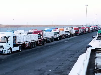 Trucks carrying humanitarian aids prepare to cross the Egyptian gate of the Rafah crossing, waiting for inspections by Israeli authorities before entering the Gaza Strip, following an agreement between Israel and Hamas on a ceasefire, Monday, Oct. 20, 2025. (AP Photo/Mohamed Arafat)