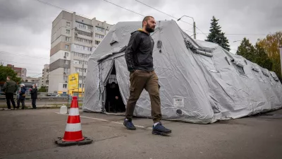 A man passes by one of the heated tents called points of invincibility, government-built help stations, during a total blackout following Russian air attacks on energy objects in Chernihiv, Ukraine, Tuesday, Oct. 21, 2025. (AP Photo/Dan Bashakov)