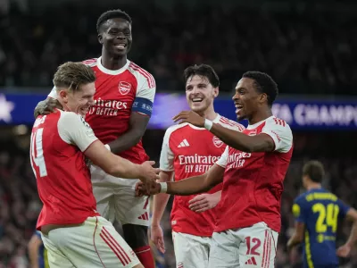 Arsenal's Viktor Gyoekeres, left, celebrates with teammates after scoring his side's third goal during the Champions League opening phase soccer match between Arsenal and Atletico Madrid in London, England, Tuesday, Oct. 21, 2025. (AP Photo/Alastair Grant)