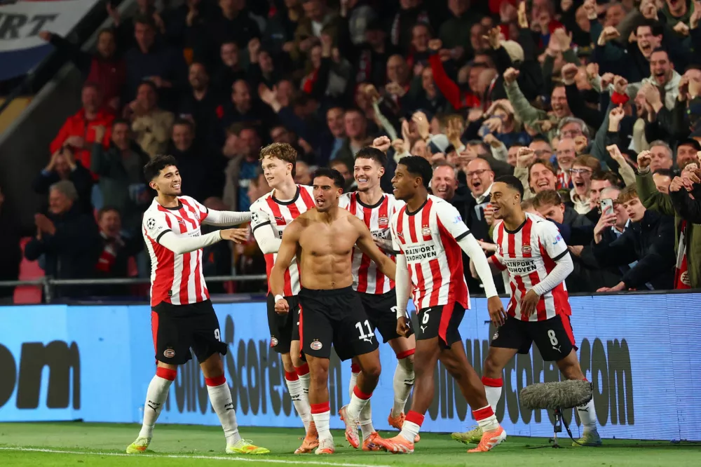 Soccer Football - UEFA Champions League - PSV Eindhoven v Napoli - Philips Stadion, Eindhoven, Netherlands - October 21, 2025 PSV Eindhoven's Couhaib Driouech celebrates scoring their sixth goal with teammates REUTERS/Piroschka Van De Wouw