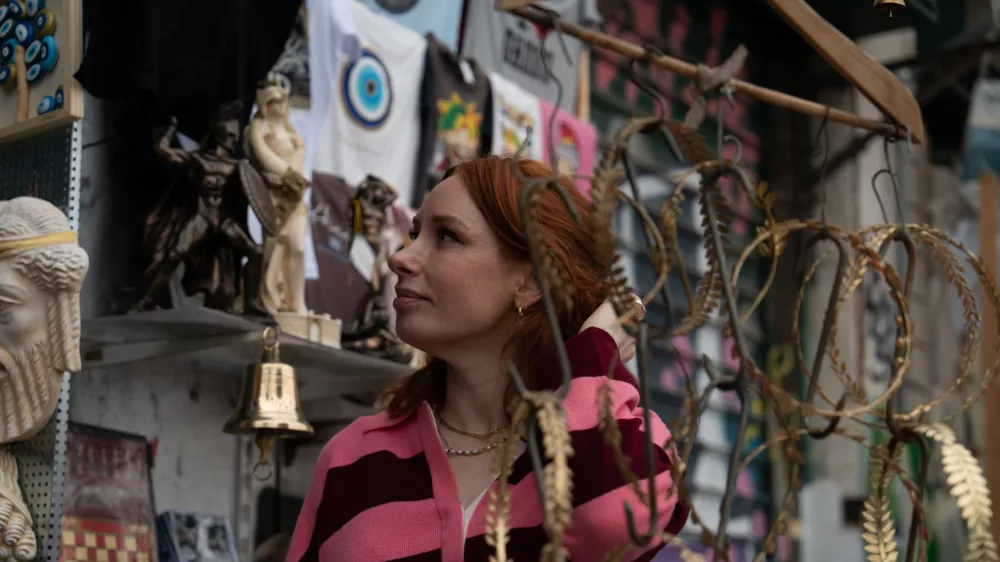 Hannah Fry at a market stall looking at items. (Zinc Television Regions) / Foto: Tess Benjamin