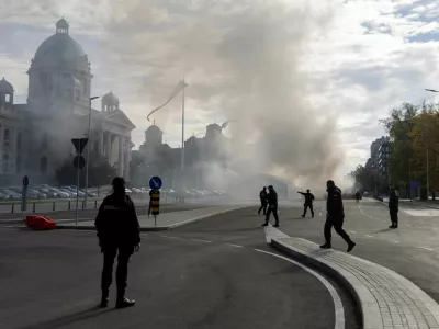 Police officers secure the area as smoke rises from a burning tent following an incident in front of the Parliament in Belgrade, Serbia, October 22, 2025. REUTERS/Djordje Kojadinovic