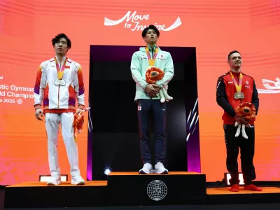 Artistic Gymnastics - 2025 World Artistic Gymnastics Championships - Mens Artistic Gymnastics - All-Around Final - Indonesia Arena, Jakarta, Indonesia - October 22, 2025 Gold medallist Japan's Daiki Hashimoto celebrates on the podium after winning the All-Around Final with silver medallist China's Zhang Boheng and bronze medallist Switzerland's Noe Seifert REUTERS/Issei Kato