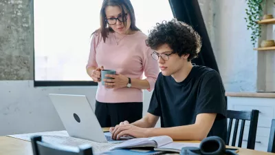 Middle aged mother and son university student, together at home in the kitchen, serious guy and woman talking looking at computer laptop. Communication, relationship, lifestyle, family concept / Foto: Valeriy_g