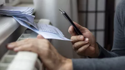 Freezing man holding phone and check bills for electricity, gas and heating. Increase in the cost of gas bill. Soaring energy prices. Increase in the price of natural gas. Energy crisis in Europe. / Foto: Anastasija Vujic, Istock