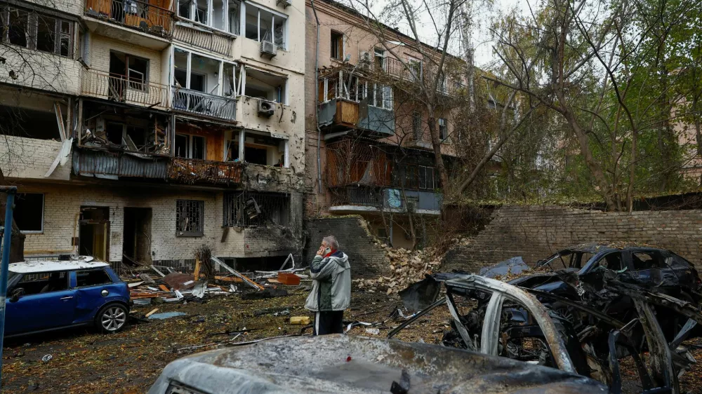 A resident talks on a mobile phone near an apartment building which was damaged during an overnight Russian drone strike, amid Russia's attack on Ukraine, in Kyiv, Ukraine October 23, 2025. REUTERS/Valentyn Ogirenko