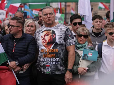 A man wearing a T-shirt with Hungarian Prime Minister Viktor Orban attends a pro-government march during celebrations marking the 69th anniversary of the outbreak of Hungary's 1956 revolution against communist rule and the Soviet Union, in Budapest, Hungary, Thursday, Oct. 23, 2025. (AP Photo/Rudolf Karancsi)