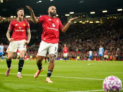 Manchester United's Bryan Mbeumo, front, celebrates with Benjamin Sesko after scoring his side's third goal during the English Premier League soccer match between Manchester United and Brighton & Hove Albion in Manchester, England, Saturday, Oct. 25, 2025. (AP Photo/Dave Thompson)