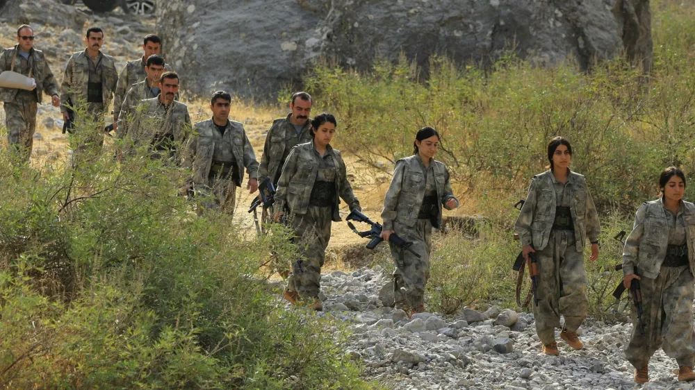 Fighters with the Kurdistan Workers' Party (PKK) walk for a disarmament ceremony marking a significant step toward ending the decades-long conflict between Turkey and the outlawed group in the Qandil mountains, Iraq October 26, 2025. REUTERS/Thaier Al-Sudani