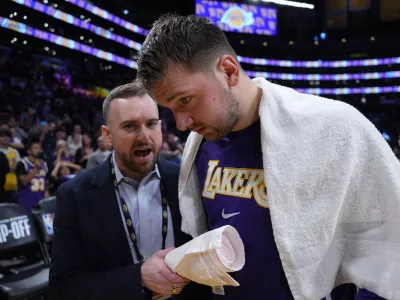 Oct 24, 2025; Los Angeles, California, USA; Los Angeles Lakers communications director Mitch Heckart (left) talks with guard Luka Doncic (77) after the game against the Minnesota Timberwolves at Crypto.com Arena. Mandatory Credit: Kirby Lee-Imagn Images