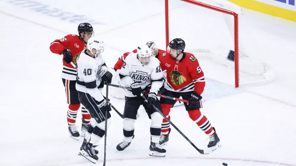 Oct 26, 2025; Chicago, Illinois, USA; Chicago Blackhawks defenseman Artyom Levshunov (55) defends against Los Angeles Kings left wing Trevor Moore (12) during the third period at United Center. Mandatory Credit: Kamil Krzaczynski-Imagn Images