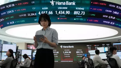 Currency traders works near a screen showing the Korea Composite Stock Price Index (KOSPI), top center left, and the foreign exchange rate between U.S. dollar and South Korean won, top center, at the foreign exchange dealing room of the Hana Bank headquarters in Seoul, South Korea, Monday, Oct. 27, 2025. (AP Photo/Ahn Young-joon)