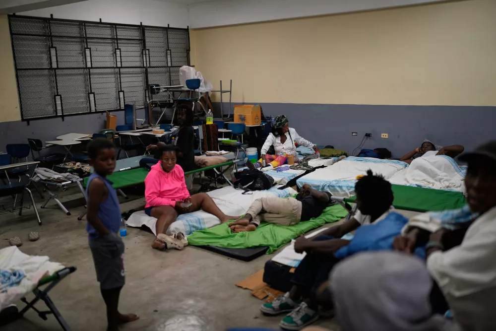 People take shelter in a school ahead of Hurricane Melissa's forecast arrival in Old Harbour, Jamaica, Monday, Oct. 27, 2025. (AP Photo/Matias Delacroix)