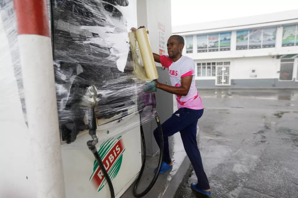 RUBiS Jamaica worker Craig Brown, wraps a gas pump, as Hurricane Melissa approaches, in Kingston, Jamaica, October 27, 2025. REUTERS/Octavio Jones