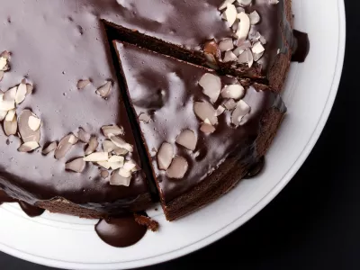Chocolate cake with chocolate frosting on black background, top view