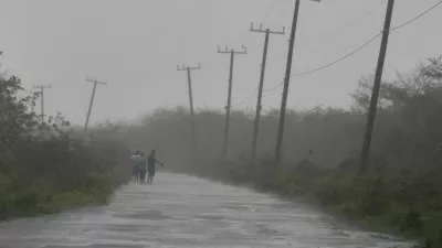 People walk along a road during the passing of Hurricane Melissa in Rocky Point, Jamaica, Tuesday, Oct. 28, 2025. (AP Photo/Matias Delacroix)